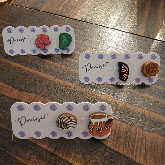 The cutest little studs of monarch butterfly and marigold, saguaro leaf and cactus flower, and barro mug with a pan dulce concha. 